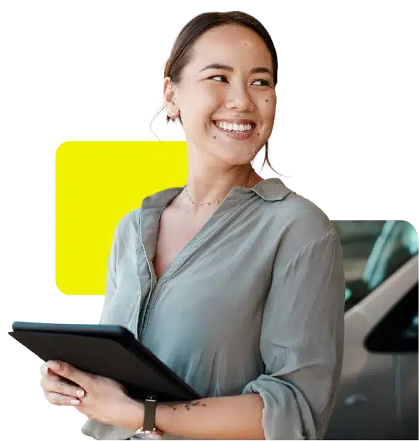 woman holding digital device in car dealership showroom