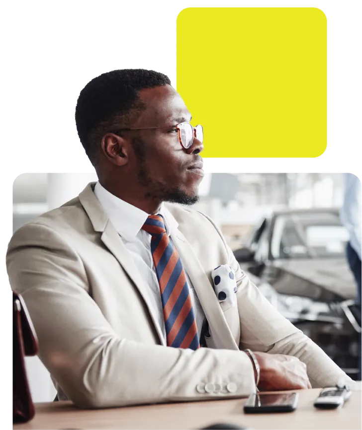 man sat in car dealership waiting to buy a car on finance